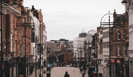 View of Briggate, Leeds with a lone, hooded figure walking away