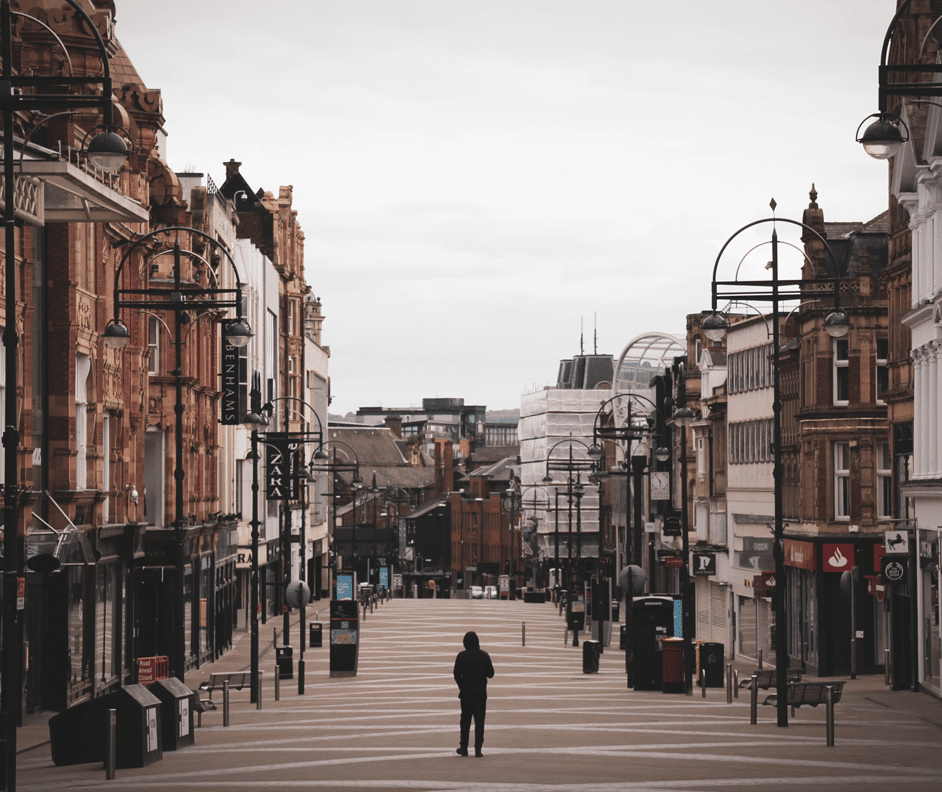 View of Briggate, Leeds with a lone, hooded figure walking away